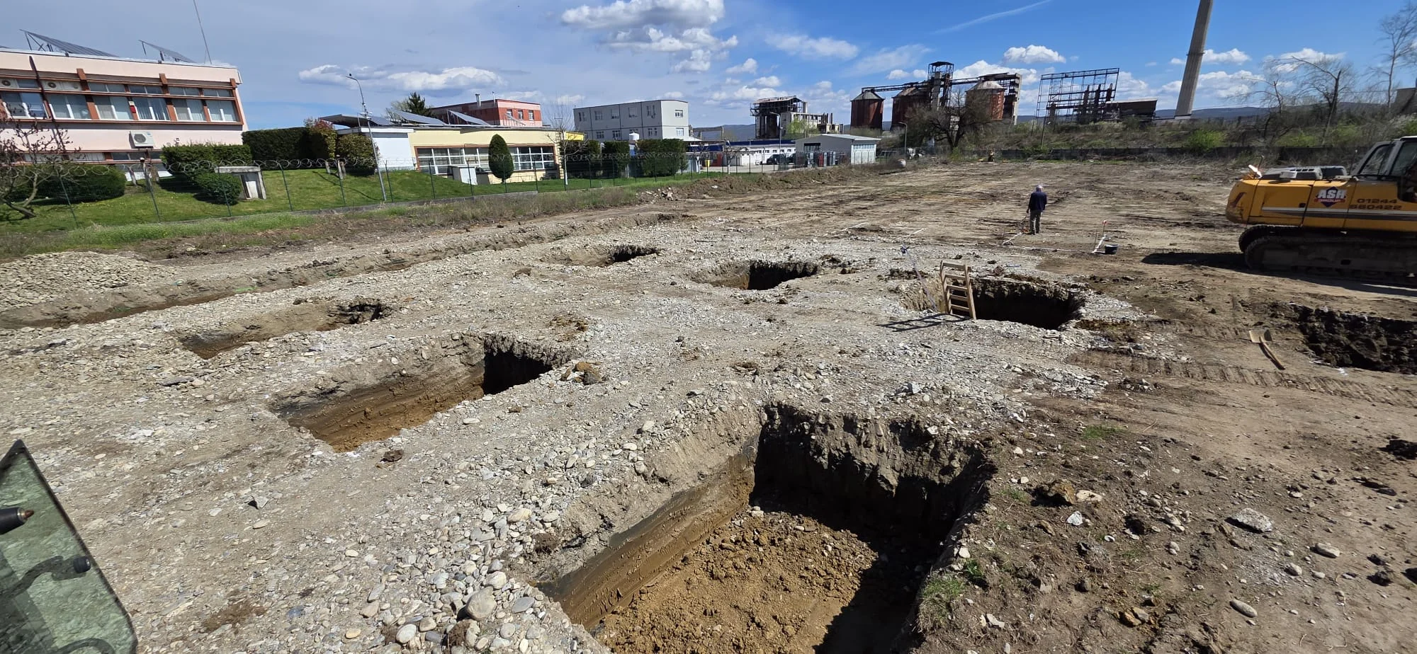 Building B construction site - foundation excavations with machinery